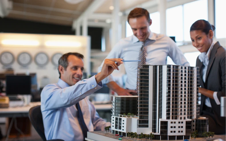 Architects discussing a scale model building.