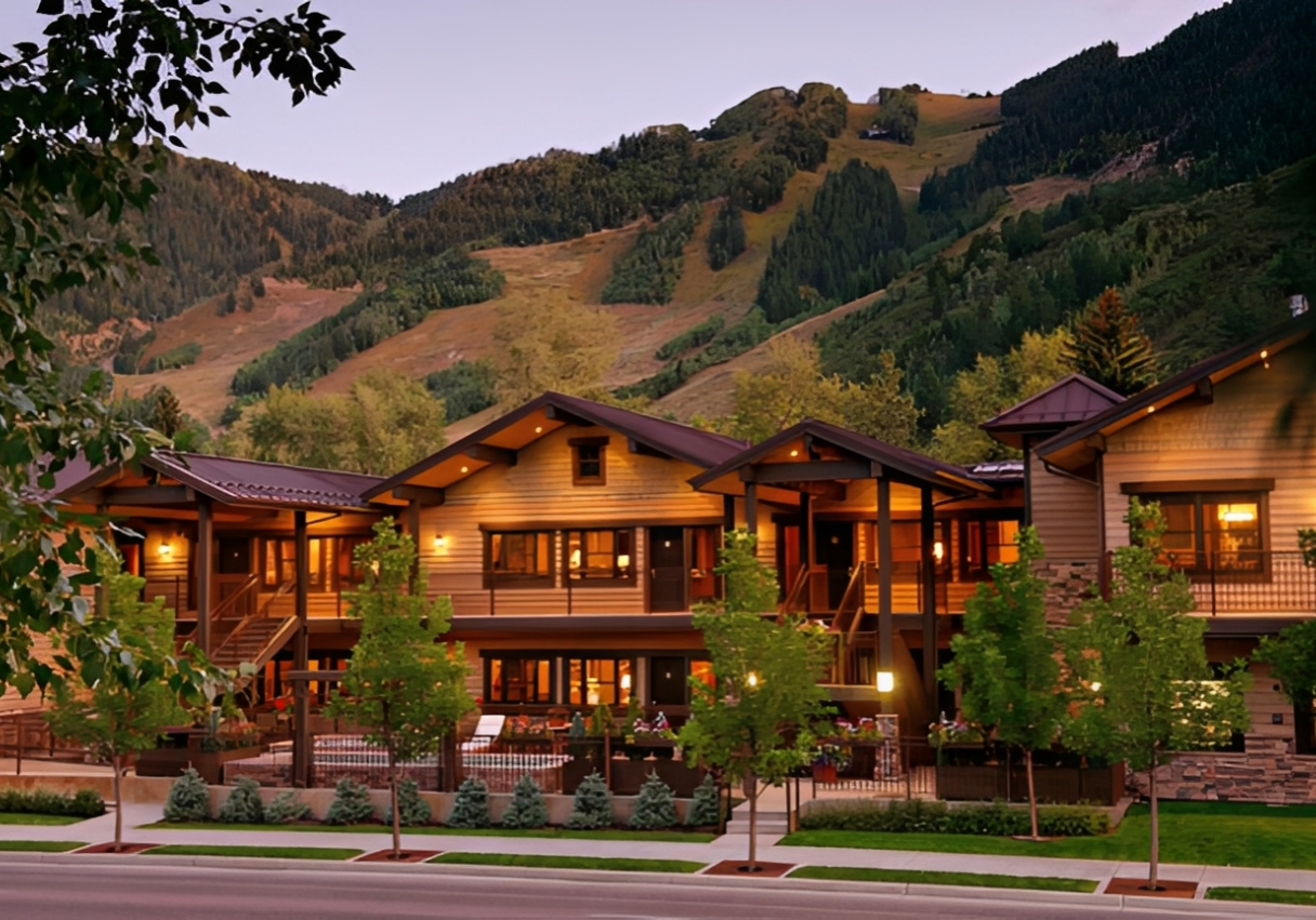 Mountain lodge with trees and evening lights.